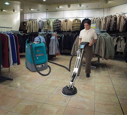 cleaning crew cleaning tile in clothing department store using Tennant Q12 multi-surface cleaning machine