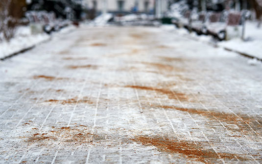brown sand and kitty litter mixture sprinkled on pavement as an alternative to salt