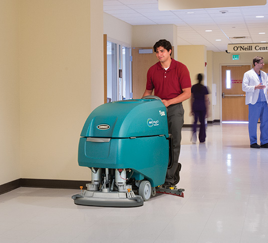 Lavadora de piso com operação a pé Tennant T500e fazendo limpeza em um hospital
